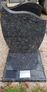 Pierre tombale en granit avec plaque noire et argentée.