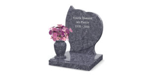 Tombe en granit avec fleurs roses.